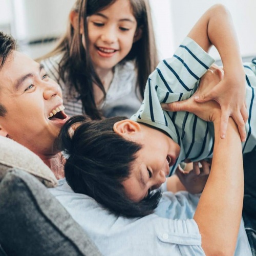 A perfect fit for the whole family father plays on a couch with his young children